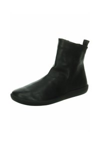 Bottine en cuir noir avec une texture douce et lisse, au design minimaliste, bout rond et semelle en caoutchouc basse. Elle présente une languette sur le talon.