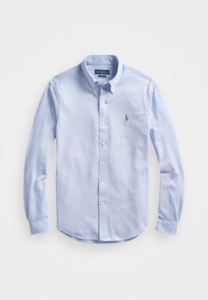 Lichtblauw overhemd met lange mouwen en knoopsluiting, kraag met knopen, witte knopen en klein geborduurd logo op de borst.