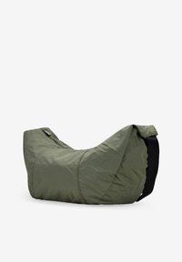 Bolso de hombro de nylon verde con una forma curva única, cuenta con un cierre de cremallera y una strap negra contrastante. Superficie texturizada con costuras visibles.