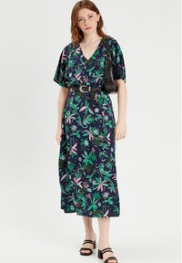 Midikleid mit floralem Druck in Marineblau, das grüne und pinke tropische Muster zeigt, mit Batwing-Ärmeln, einem V-Ausschnitt und einer taillierten Taille.