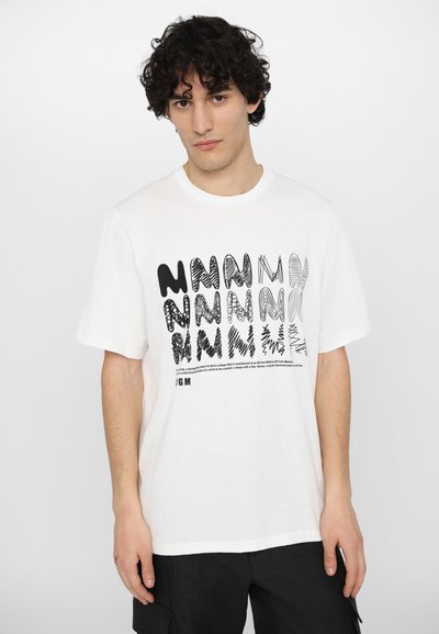 T-shirt bianco in cotone con un design grafico nero che presenta diverse variazioni della lettera "N" in stili e forme differenti. Maniche corte.