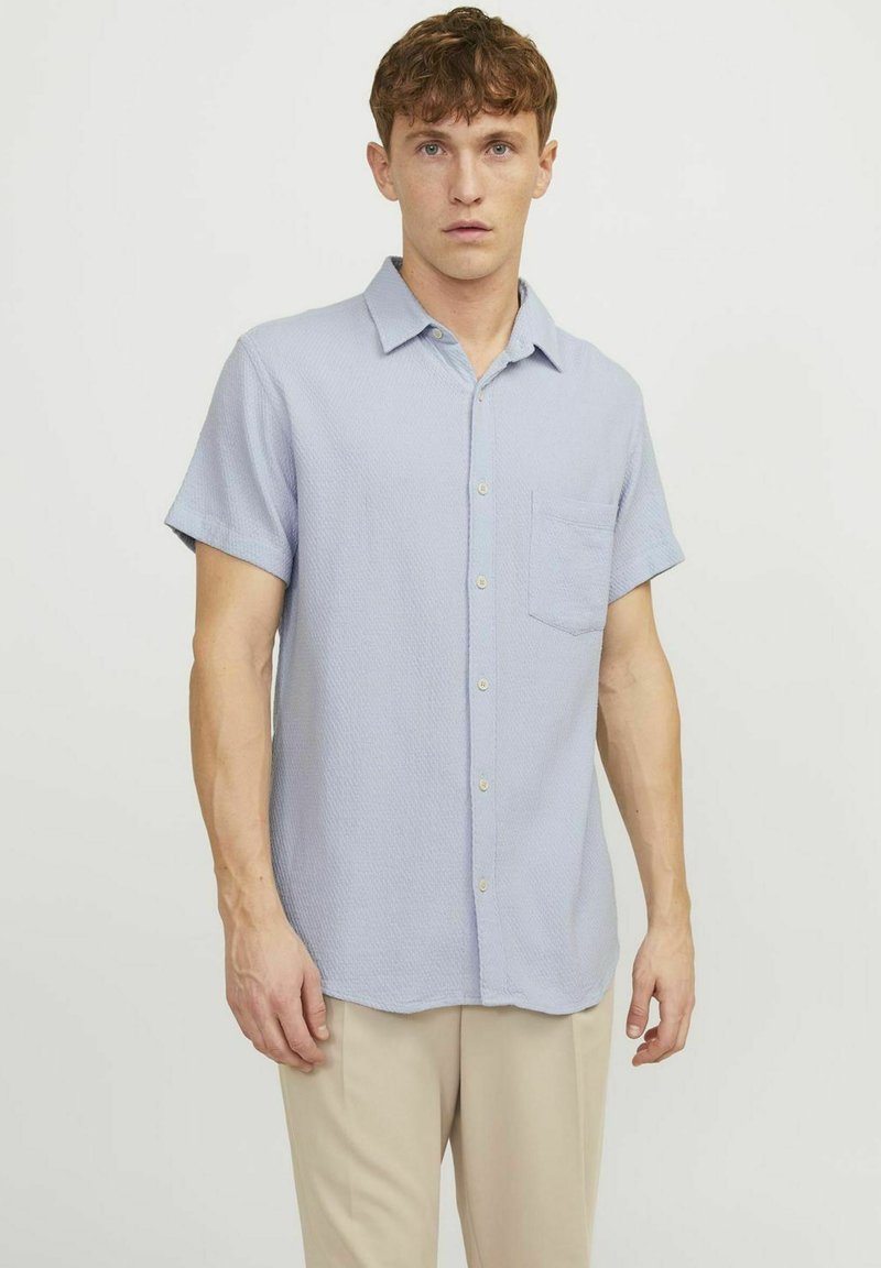 Lichtblauw kortearmsgem shirt met een gestructureerd patroon, knoopsluitingen aan de voorkant en een borstzak; gemaakt van geweven stof.