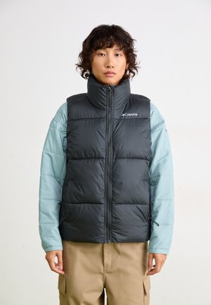Black puffy vest with high collar and zipper, worn over a light blue long-sleeve shirt. Smooth nylon fabric with stitch details.