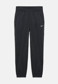 Pantalons de sport noirs en tissu léger, avec une taille élastique et des poignets ajustés, arborant un petit logo Nike en argent sur le côté.