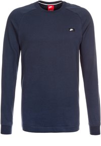 Marinblå långärmad sweatshirt i bomullsmaterial. Har ribbade muddar, rund hals och en liten svart Nike-logotyp på bröstet.