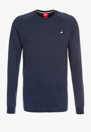 Marineblaues Langarm-Sweatshirt aus Baumwollmischung. Verfügt über gerippte Bündchen, Rundhalskragen und ein kleines schwarzes Nike-Logo auf der Brust.