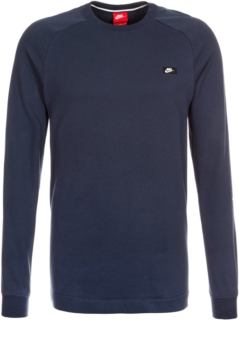 Marinblå långärmad sweatshirt i bomullsmaterial. Har ribbade muddar, rund hals och en liten svart Nike-logotyp på bröstet.