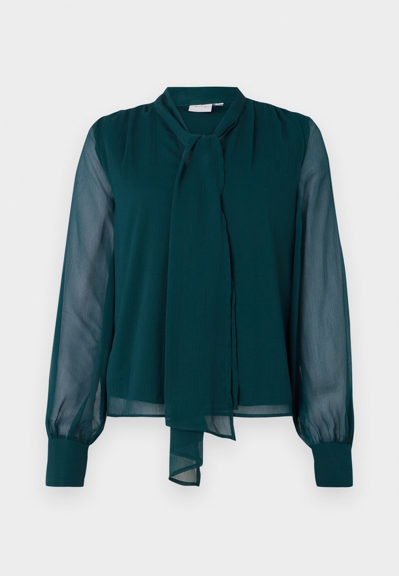 Blouse turquoise avec des manches longues en voile, un détail de nœud au cou et une coupe légèrement ample. Fabriquée en tissu léger avec une texture lisse.