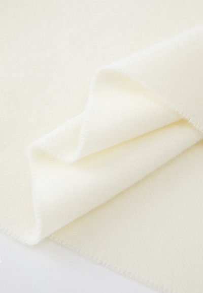 Tessuto di colore crema con una superficie morbida, caratterizzato da una leggera lucentezza e bordi rifiniti in modo ordinato, piegato per mettere in risalto la sua superficie liscia.