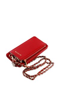 Červená kožená crossbody taška se zlatým řetízkovým popruhem, zipovým uzamčením a vypouklým názvem značky. Disponuje kompaktním, obdélníkovým designem.