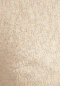 Licht beige gebreid stof met een zachte textuur, met een subtiel patroon van pluizigheid en een licht gemêleerd uiterlijk.