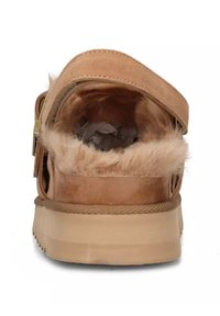 Infradito color cammello con tomaia in suede, fodera in pelliccia morbida e suola robusta in gomma. Presenta una tracolla regolabile per una vestibilità sicura.