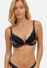 Soutien-gorge noir avec des bordures en dentelle, orné de motifs floraux colorés sur les bonnets et d'un détail en nœud rose au centre. Bretelles réglables avec des accents dorés.