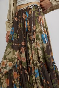 Lagana, smeđa suknja s cvjetnim uzorkom, izrađena od lagane tkanine s naborima u slojevima, ukrašena plavim i breskvastim cvjetnim motivima i detaljem vezivanja u struku.