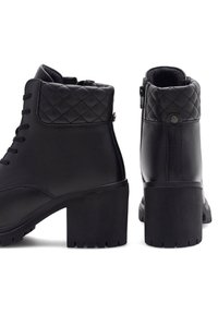 Botine negre până la glezna, cu un gât din piele sintetică matlasată, șireturi în față, fermoar pe lateral și toc texturat, robust. Partea superioară cu textură și finisaj neted.