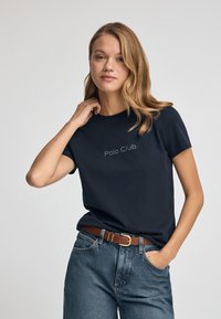 Camiseta de algodón de color azul marino con mangas cortas y cuello redondo, que presenta "Polo Club" bordado en blanco en el frente.