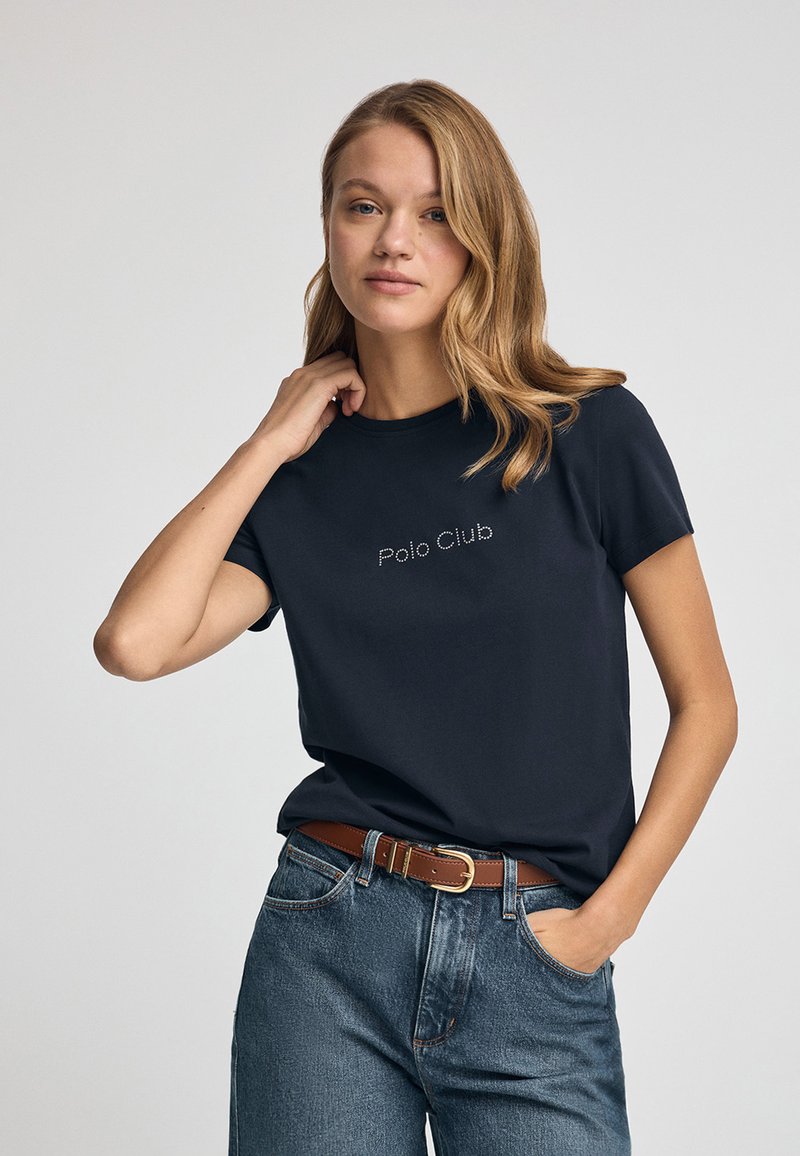 Camiseta de algodón de color azul marino con mangas cortas y cuello redondo, que presenta "Polo Club" bordado en blanco en el frente.