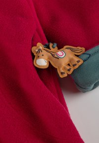 Indumento in pile di un rosso intenso con un bordo verde e un'applicazione decorativa di un cavallo beige, con dettagli cuciti e una superficie liscia.