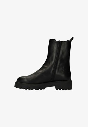 Bottine en cuir noir avec fermeture éclair sur le côté, semelle crantée épaisse et tirant à l'arrière, présentée en profil latéral.