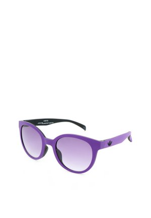 Occhiali da sole viola a goccia con lenti grigie sfumate e logo nero Adidas trifoglio sulle aste, mostrati su sfondo bianco.