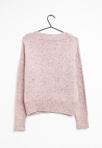 Jasnoróżowy sweter dziany o nakrapianej fakturze, z prążkowanymi mankietami i dołem, okrągłym dekoltem i luźnym krojem, wiszący na czarnym wieszaku.
