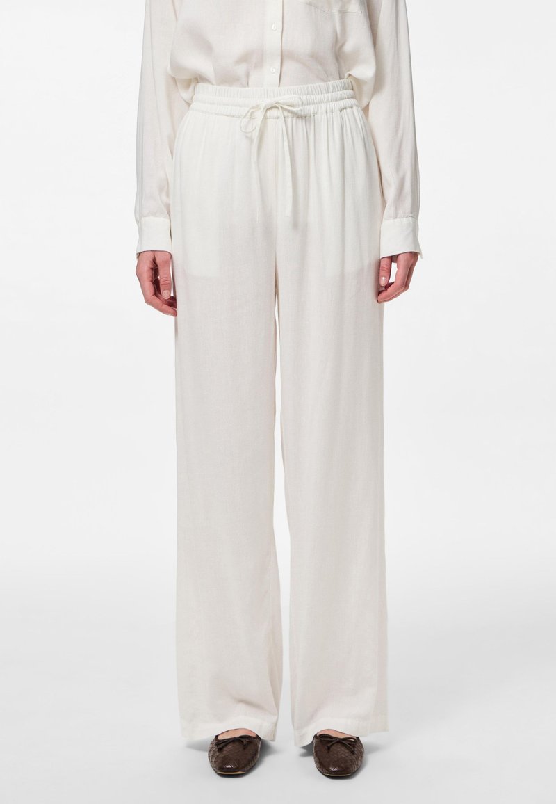 Pantalons larges blancs en tissu léger avec une taille élastique et un cordon de serrage. Texture lisse, sans motifs ni accents visibles.