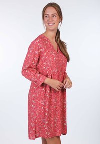 Rotes Blumenkleid mit V-Ausschnitt und langen Ärmeln, mit einer gerafften Taille und lockerer Passform, aus leichtem Stoff gefertigt.