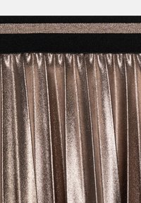 Metallische geplooide stof in roségoud met een gestructureerd oppervlak en een zwarte tailleband met een decoratieve glanzende band.