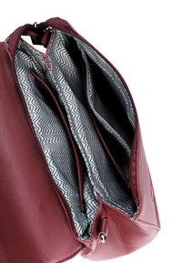 Burgunderfarbene Lederhandtasche mit einem Reißverschluss, die drei Innenfächer hat, gefüttert mit einem grauen Stoff im Zickzackmuster.