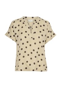 Haut beige à manches courtes avec un décolleté en V, arborant un motif de grands pois marron sur l'ensemble. Fabriqué en tissu doux et léger.