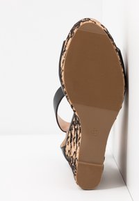 Sandale à talons hauts pour femme avec semelle texturée couleur noisette, superposition en dentelle noire et bride à la cheville, taille 37 indiquée sur la semelle.