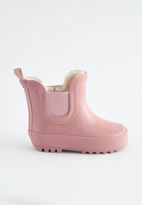 Roze rubberen enkellaars met bontvoering, gestructureerd bovenwerk, patroonzool en elastische zijpanelen voor gemakkelijk aan- en uittrekken. Heeft een trekstapje aan de hiel.