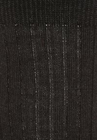 Tessuto nero lavorato a maglia con linee verticali e piccole aperture, che mette in mostra una texture ruvida e una trama allentata, adatto per abbigliamento informale.