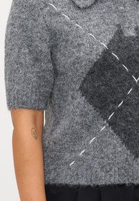 Gray knitted sweater with a textured finish, featuring short sleeves, a collar, and a geometric pattern in darker gray with white stitched accents.