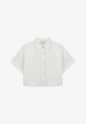 Camisa blanca de manga corta con cuello, con un patrón texturizado, que presenta un cierre de botones frontal y un diseño recortado.