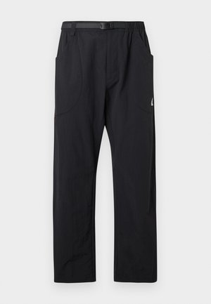 Könnyű fekete nadrág rugalmas derékkal, két oldalzsebbel és egy kis logóval a bal oldalon, sima textúrával.