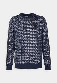 Sudadera navy de manga larga, con un patrón de logotipos EA7 que se repite. Cuello redondo y un tejido suave y texturizado. Corte estándar.