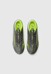 Black and neon green sports shoes with a textured upper, sleek design, lace closures, and dynamic, angled line patterns.