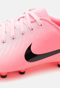 Rosa fotballsko med teksturert overdel, svart Nike-logo og rosa lisser. Har seks svarte pigger for godt grep på sålen.