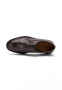 Bruine lederen dresschoen met een gladde afwerking, ronde neus, vetersluiting en subtiele stikdetails. Inclusief een zwarte rubberen zool.