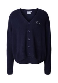 Námořnický modrý cardigan s V-výstřihem, šesti knoflíky, ribbovaným lemem a manžetami, se malým vyšitým detailem na levém prsu.