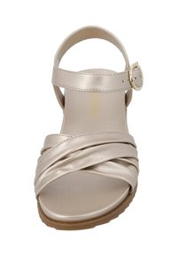 Metallisch goldene Sandalen mit einem Kreuzdesign; verstellbarer Knöchelriemen mit einer goldenen Schnalle; flache Sohle.