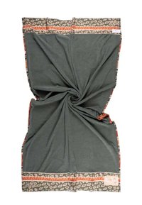 Coperta verde con texture vorticosa. Presenta un bordo decorato in tonalità terra di arancione e crema, con elementi floreali e un'etichetta di brand.