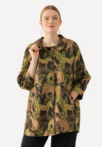 Jas met bloemmotief in donkerbruin met groene en roze dierenontwerpen. Heeft een kraag en zijzakken.