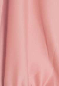 Tissu rose lisse avec des plis doux et une texture subtile, montrant un drapé délicat et une légère ombre.