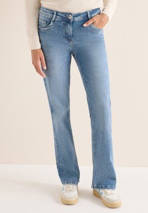 Lyseblå denimjeans, lige ben, fem-lomme-design, lynlås med knap, mellem vask, subtilt falmet, båret med hvide sneakers.