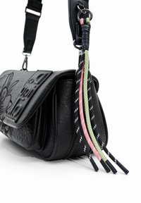 Schwarze Lederhandtasche mit geprägtem Blumendesign und Reißverschluss. Verstellbarer Tragegurt und bunte geflochtene Akzente verleihen Details.