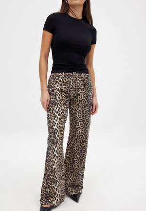 Zwarte short-sleeve top gecombineerd met wijde broek met luipaardprint, gemaakt van textuurstof, met variërende bruine en zwarte patronen.