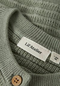 Svetlozeleni pleteni pulover z teksturiranim vzorcem, rebrastim ovratnikom in lesenim gumbom. Oznaka pravi "Lil'Atelier," velikost 1-2M.