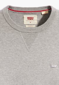 Gray sweatshirt with ribbed crew neck, featuring a red accent. Includes a sewn-in label and a small embroidered Levi's logo on the chest.